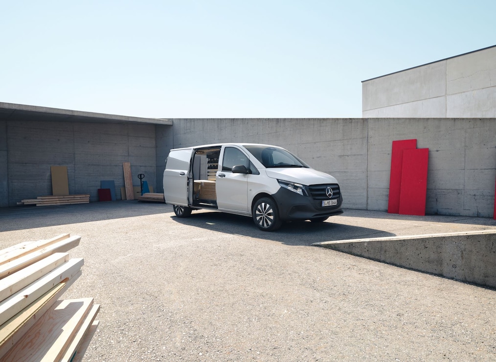 Skříňová dodávka Mercedes-Benz Vito v&nbsp;průmyslové oblasti s&nbsp;otevřenými posuvnými dveřmi na pravé straně řidiče.