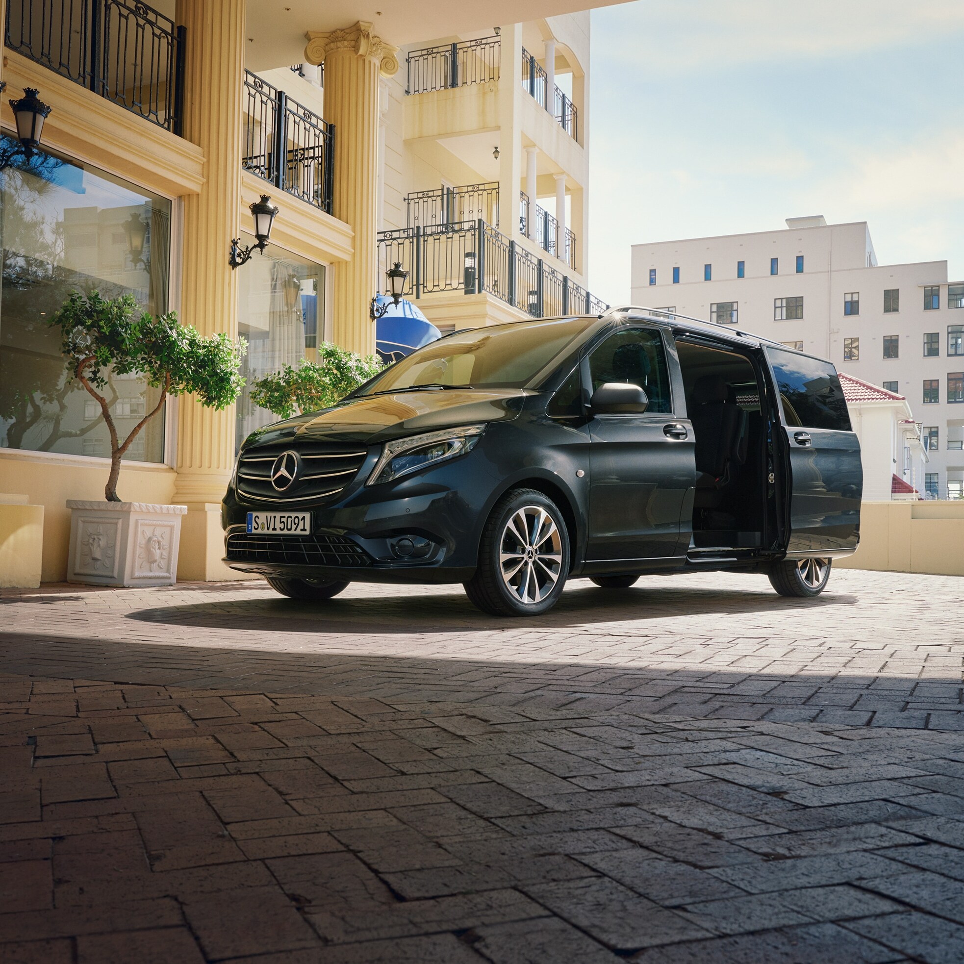 Mercedes-Benz Vito Tourer zaparkovaný u vchodu do luxusní budovy