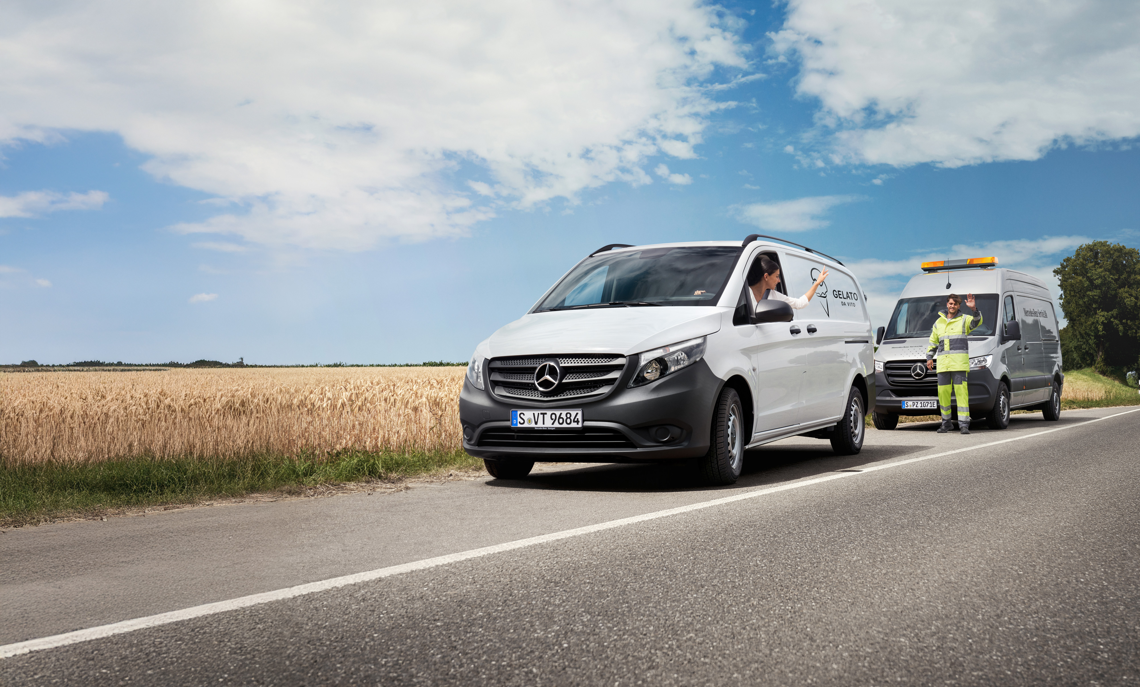 Mercedes-Benz | Vans Care | Asistenční služba Osoba v bílém dodávkovém vozidle Mercedes-Benz Vito mává servisnímu technikovi zaparkovanému na krajnici.