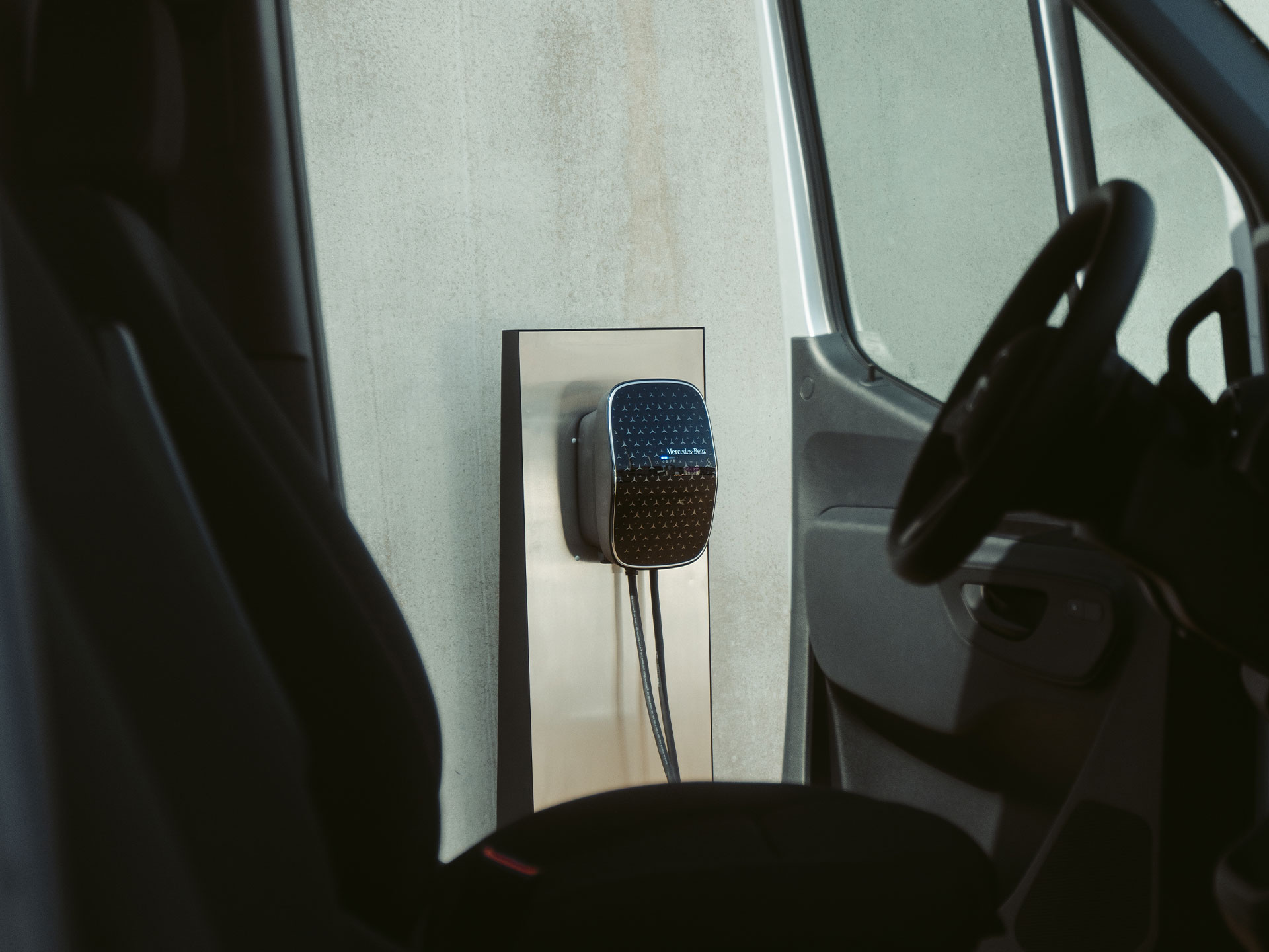 Nabíjení doma | Nabíjení | Dodávková vozidla Mercedes-Benz Elektrické užitkové dodávkové vozidlo Mercedes-Benz nabíjející se pomocí wallboxu Mercedes-Benz.