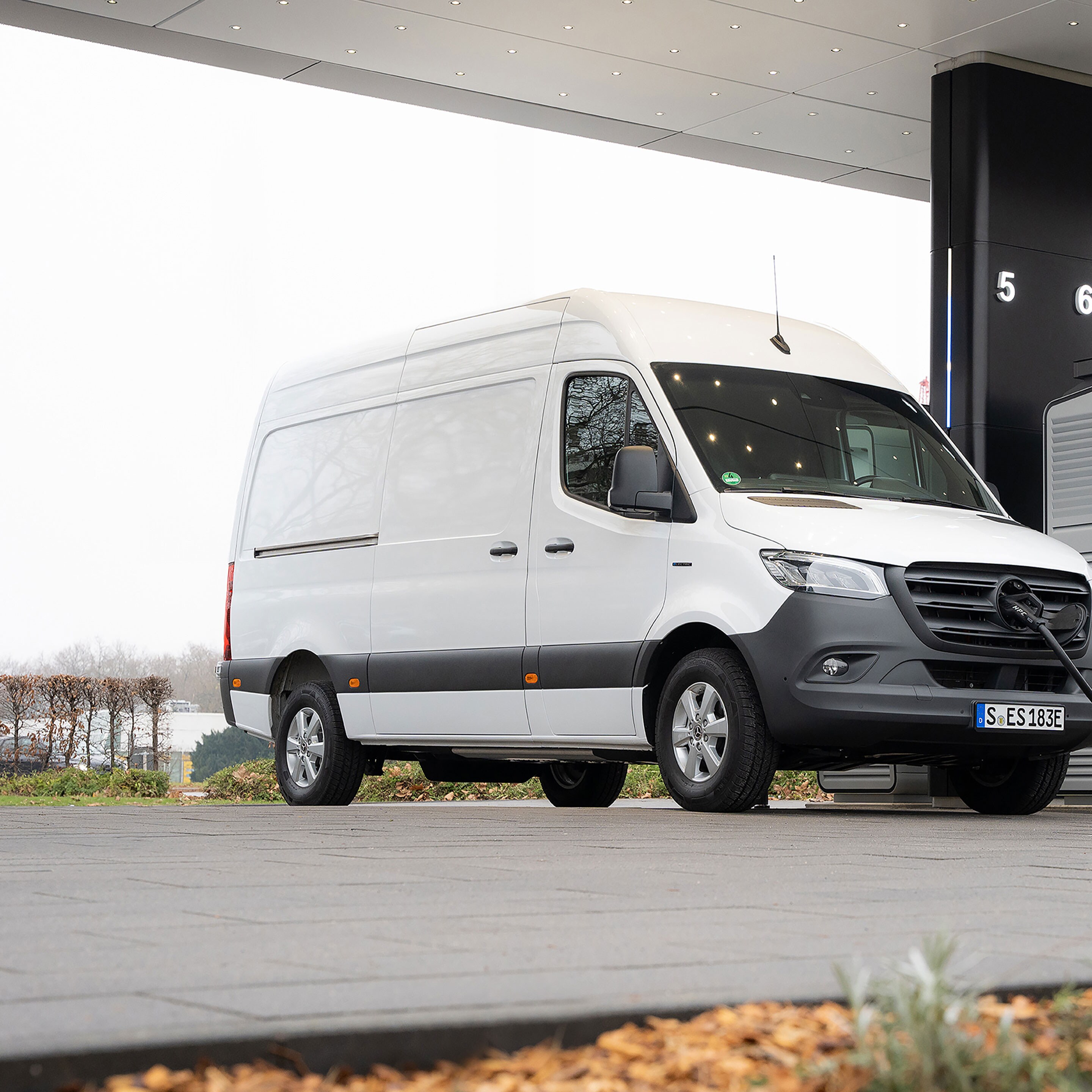 Dodávkové vozidlo Mercedes-Benz před nabíjecí stanicí během nabíjení.
