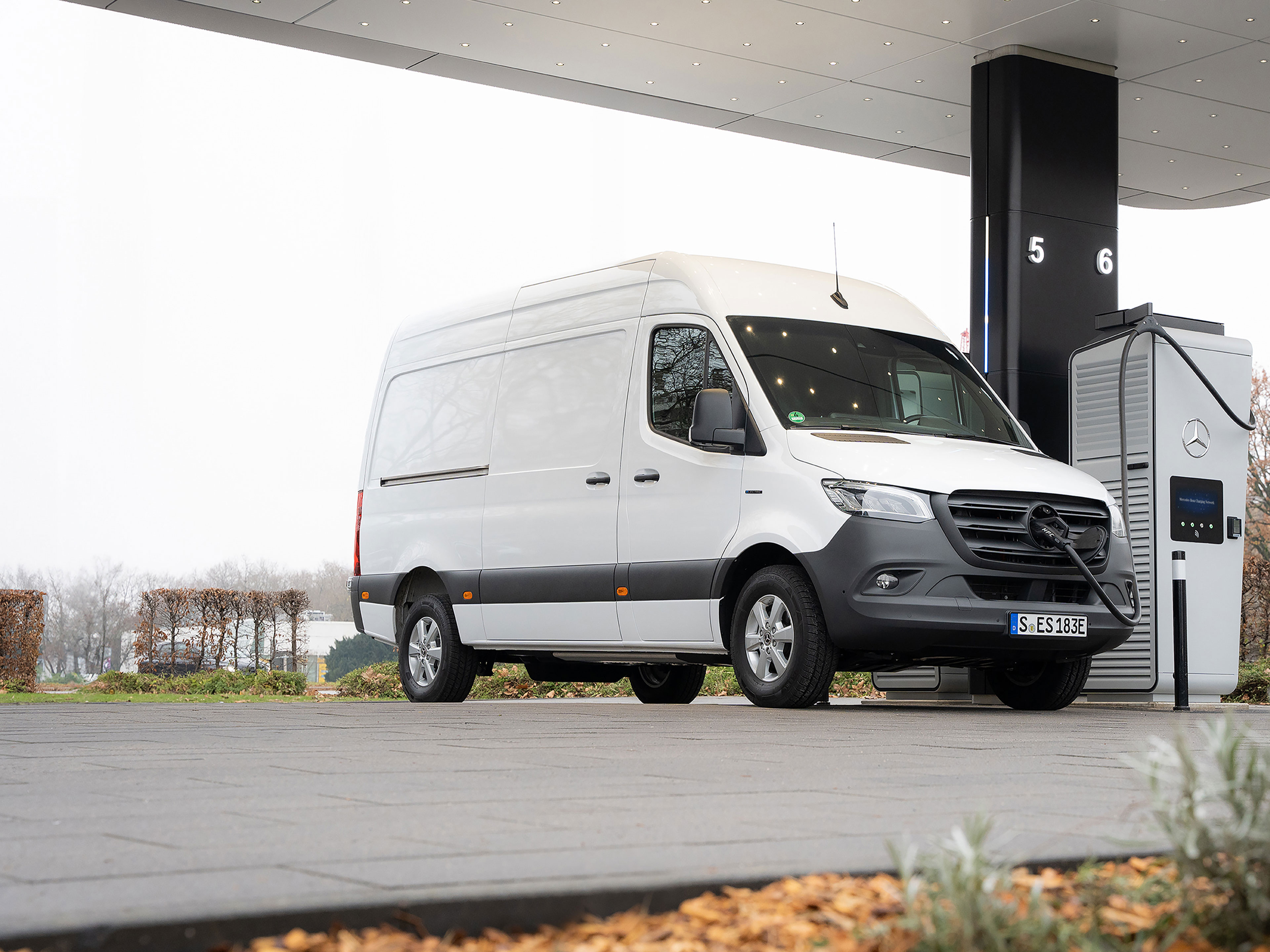 Nabíjecí síť Mercedes-Benz | Nabíjení na cestách | Dodávková vozidla Mercedes-Benz Dodávkové vozidlo Mercedes-Benz před nabíjecí stanicí během nabíjení.