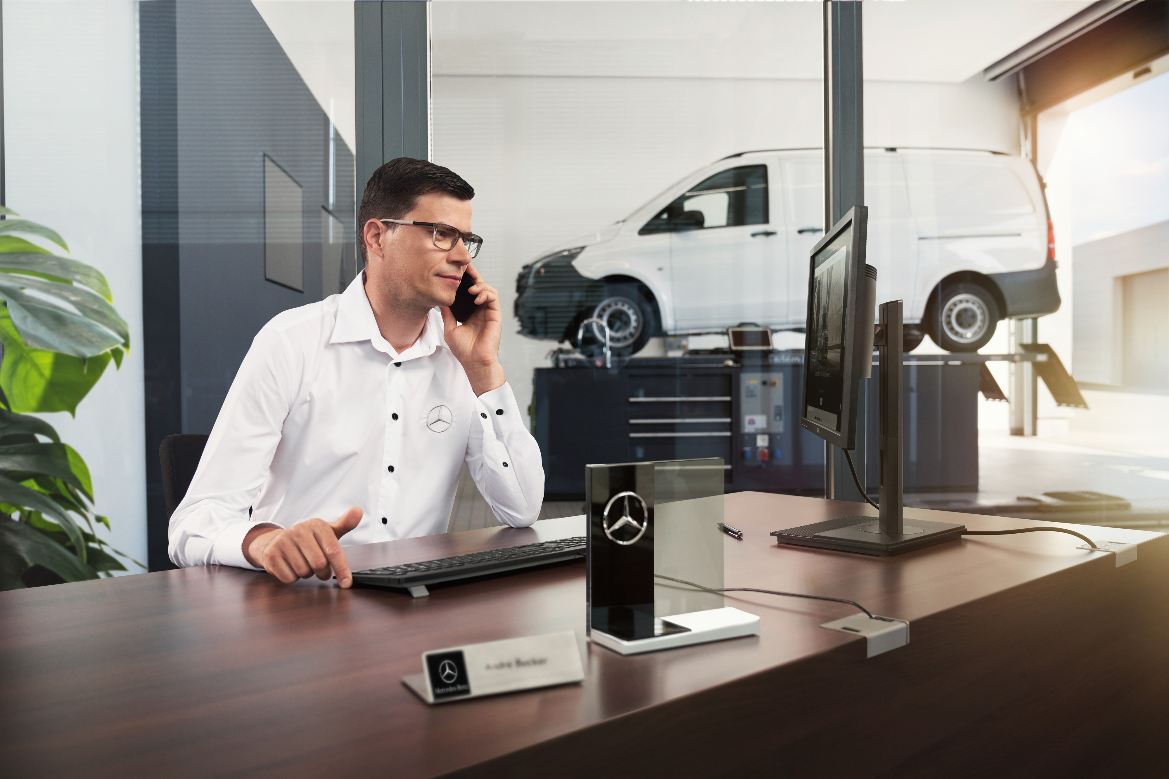 Mercedes-Benz | Pohodlí | Servisní partner Přijímací technik Mercedes-Benz telefonuje v dílně.