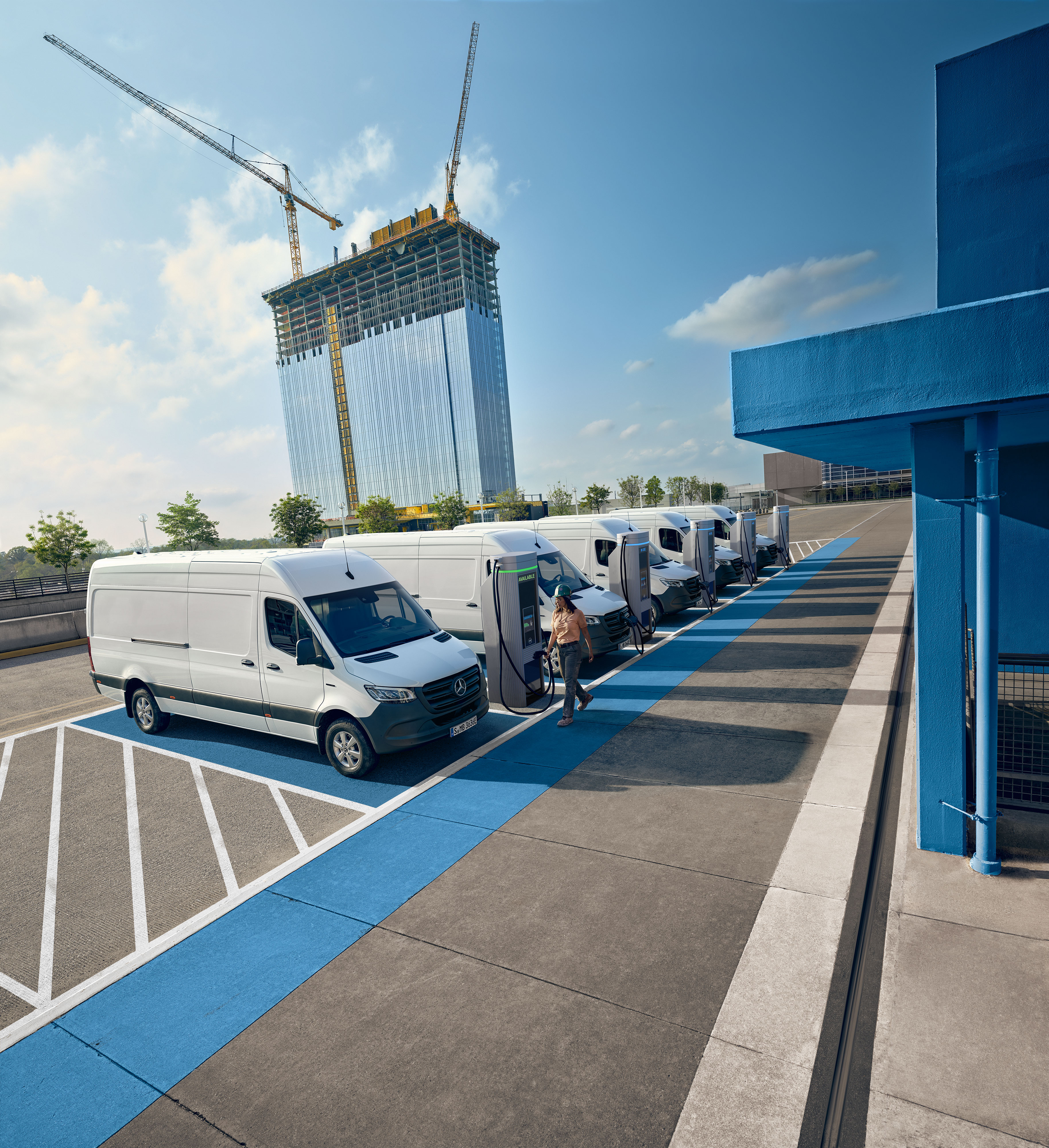 Mercedes-Benz | Pohodlí Vozový park bílých elektrických dodávek Mercedes-Benz zaparkovaných u nabíjecího centra.