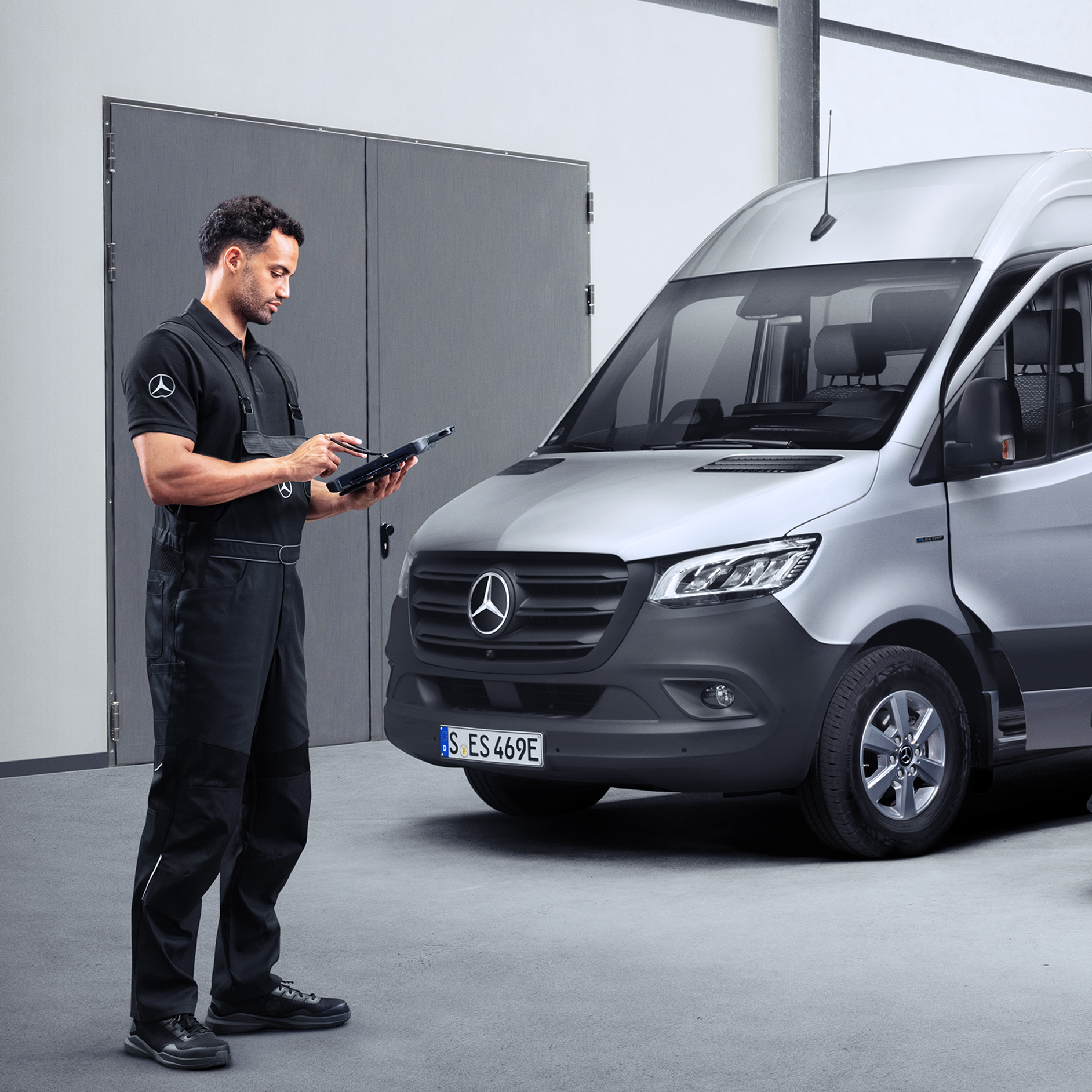 Servisní partner Mercedes-Benz | Údržba a prohlídka Servisní partner Mercedes-Benz s tabletem, který stojí před vozidlem Mercedes-Benz eSprinter.