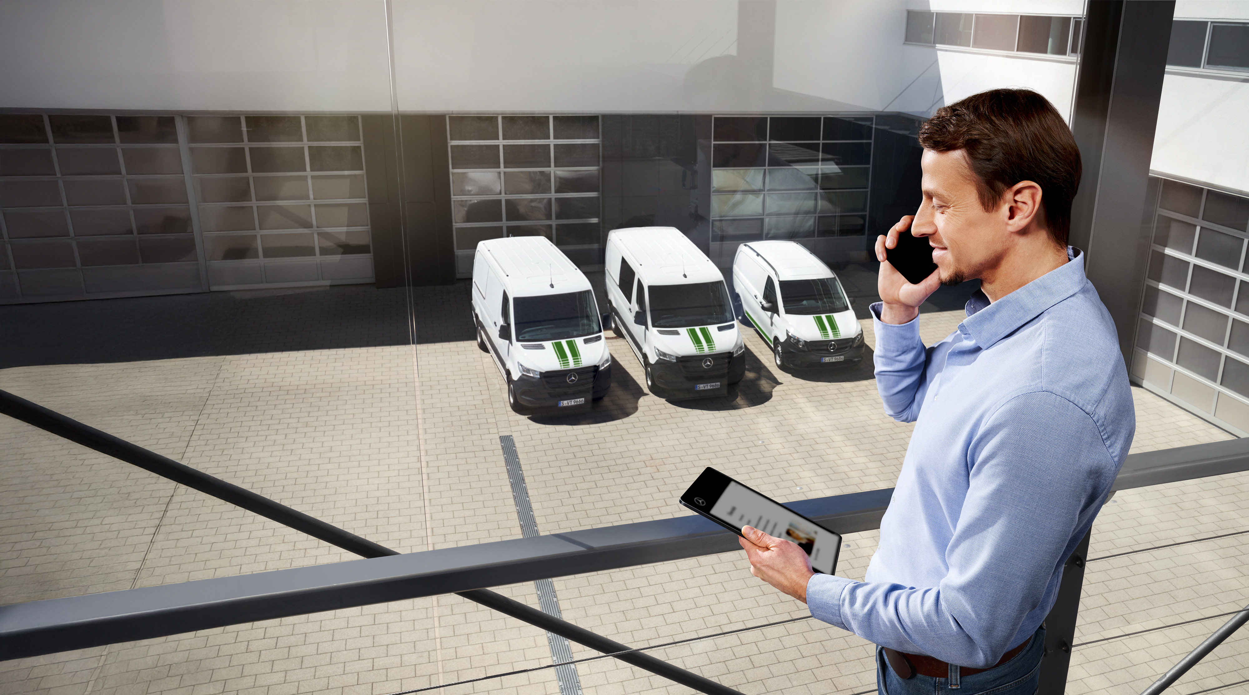 Mercedes-Benz | Přehled kvality dodávkových vozidel Muž s tabletem a mobilním telefonem před třemi dodávkovými vozidly Mercedes-Benz, symbolizujícími kvalitu a spolehlivost kalibru Mercedes-Benz.