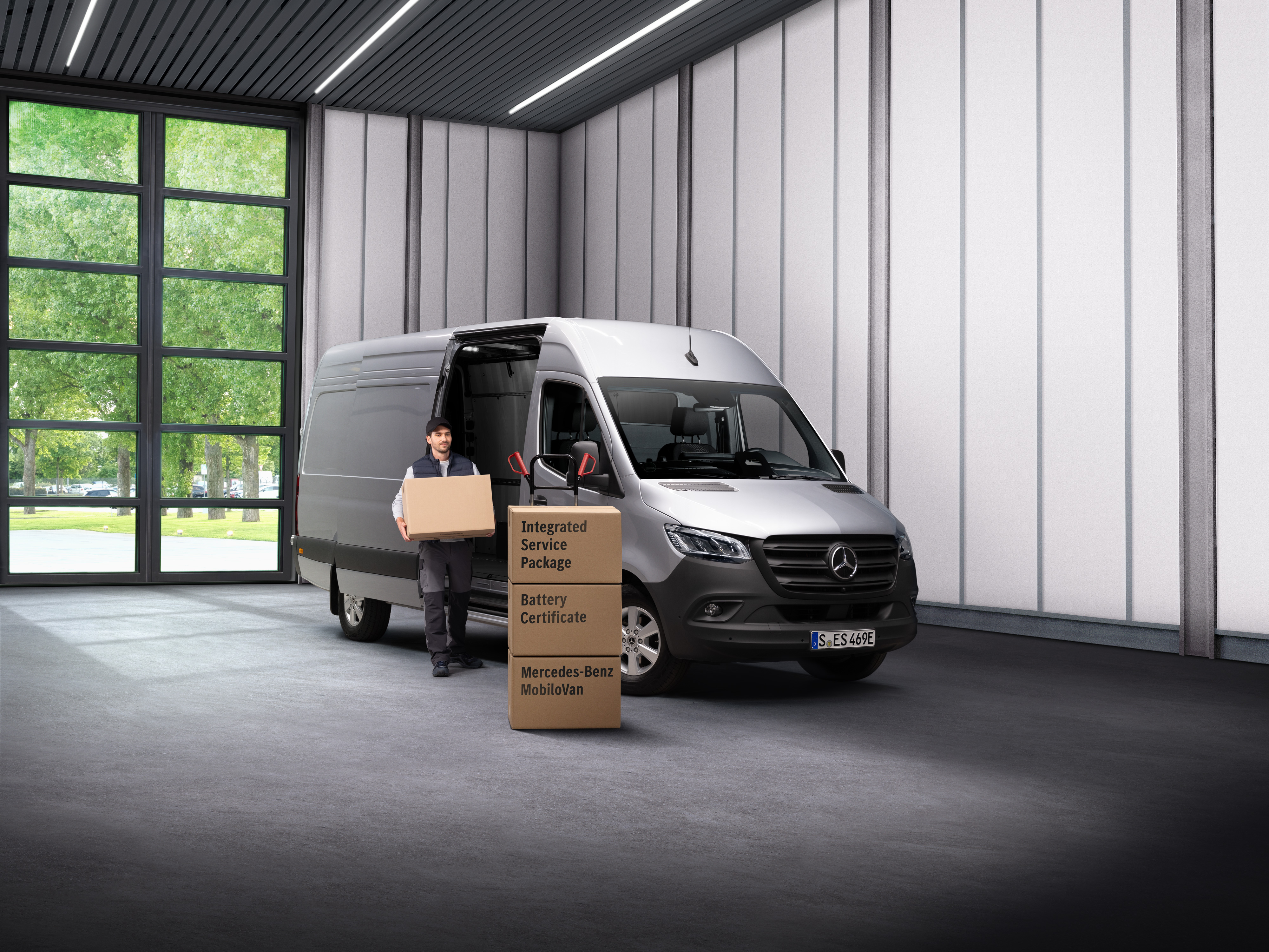Mercedes-Benz | Servis pro elektromobily Zaměstnanec servisu pro elektromobily Mercedes-Benz vynáší krabice z dodávkového vozu