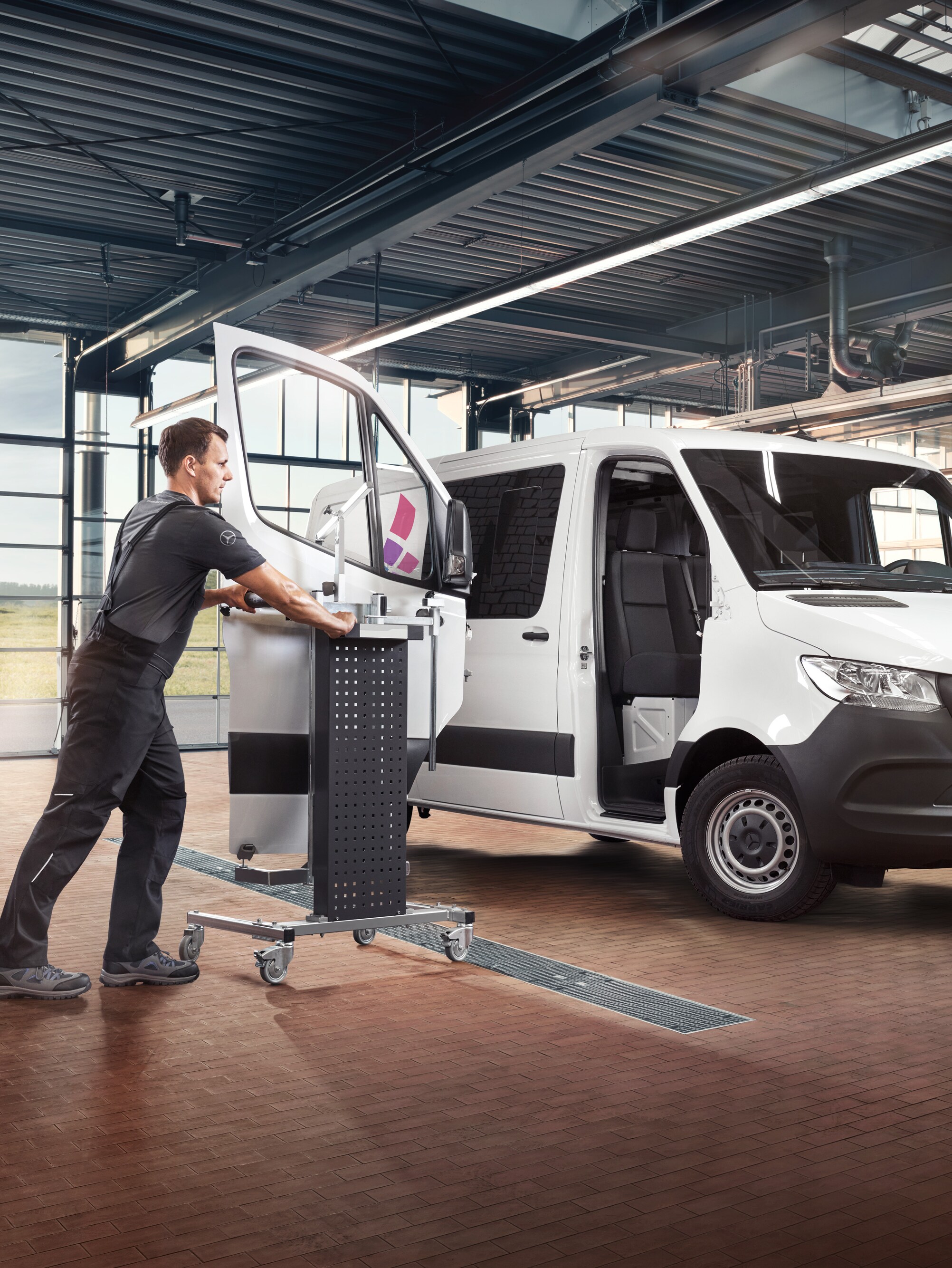 Technik provádí údržbu dveří spolujezdce u&nbsp;bílého dodávkového vozidla Mercedes-Benz Sprinter.