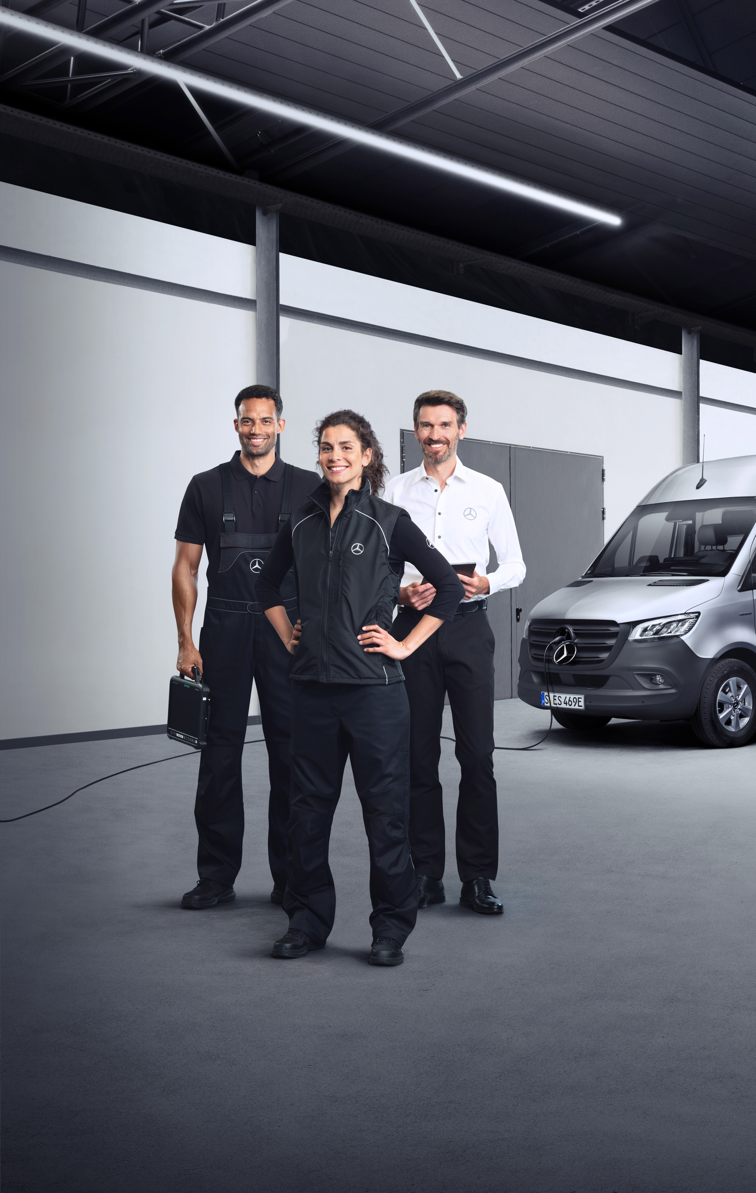 Mercedes-Benz | Servis pro elektromobily Tři zaměstnanci před elektrickým dodávkovým vozidlem Mercedes-Benz Sprinter s připojeným nabíjecím kabelem.
