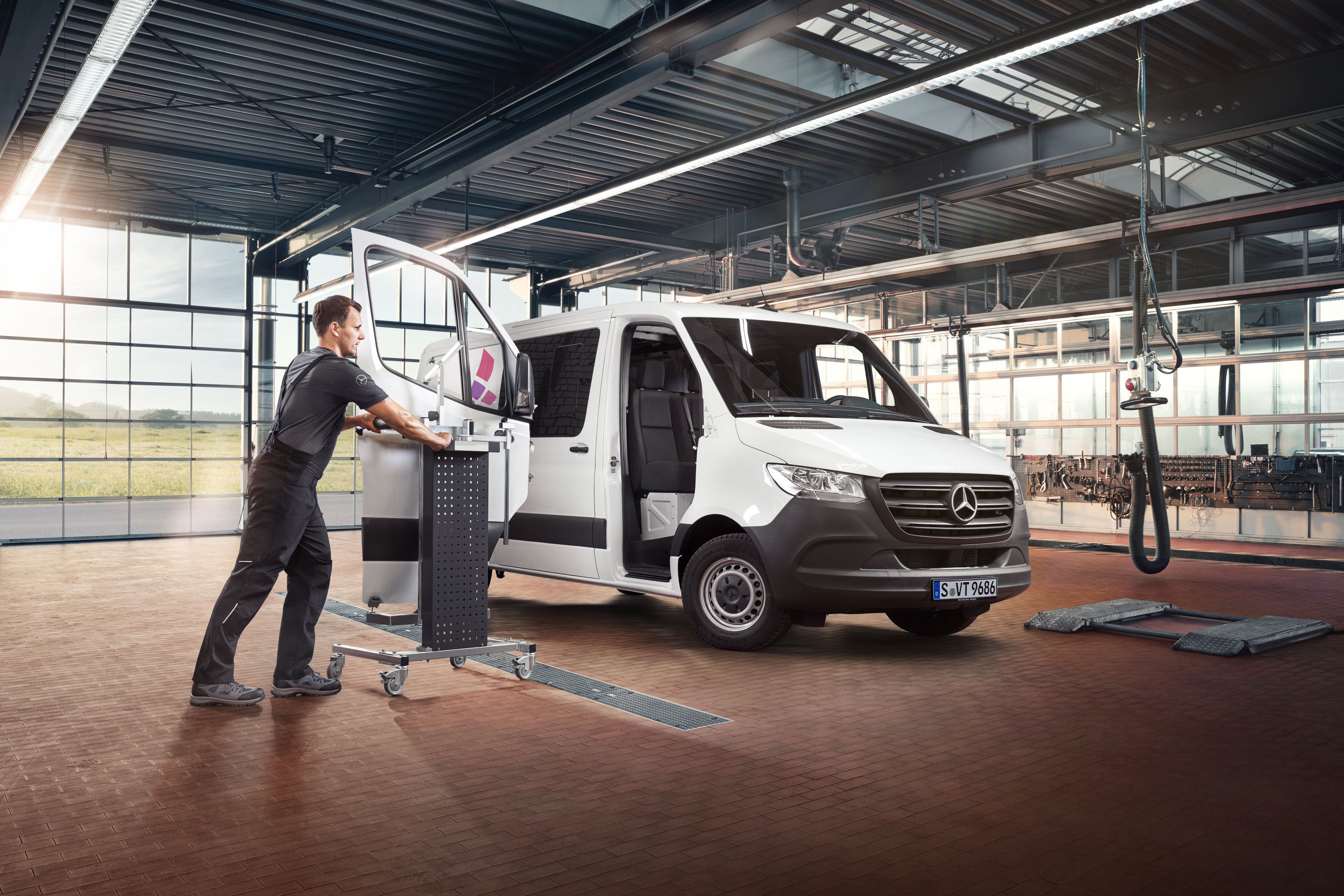 Mercedes-Benz | Oprava Mechanik montující dveře na bílé dodávkové vozidlo Mercedes-Benz Sprinter.