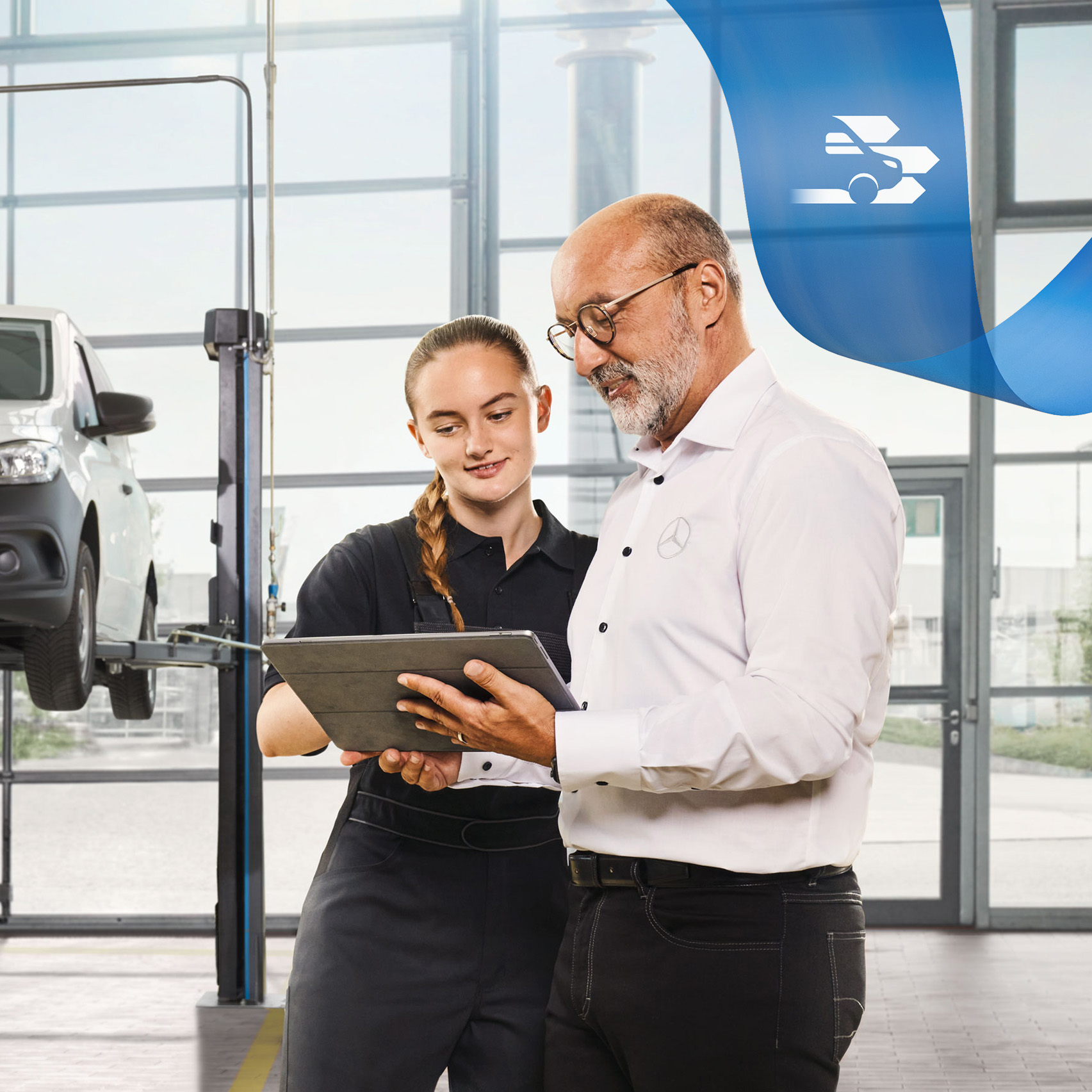 Mercedes-Benz | Údržba Dva zaměstnanci diskutují v dílně o servisu užitkového vozidla u zvednutého dodávkového vozidla Mercedes-Benz.