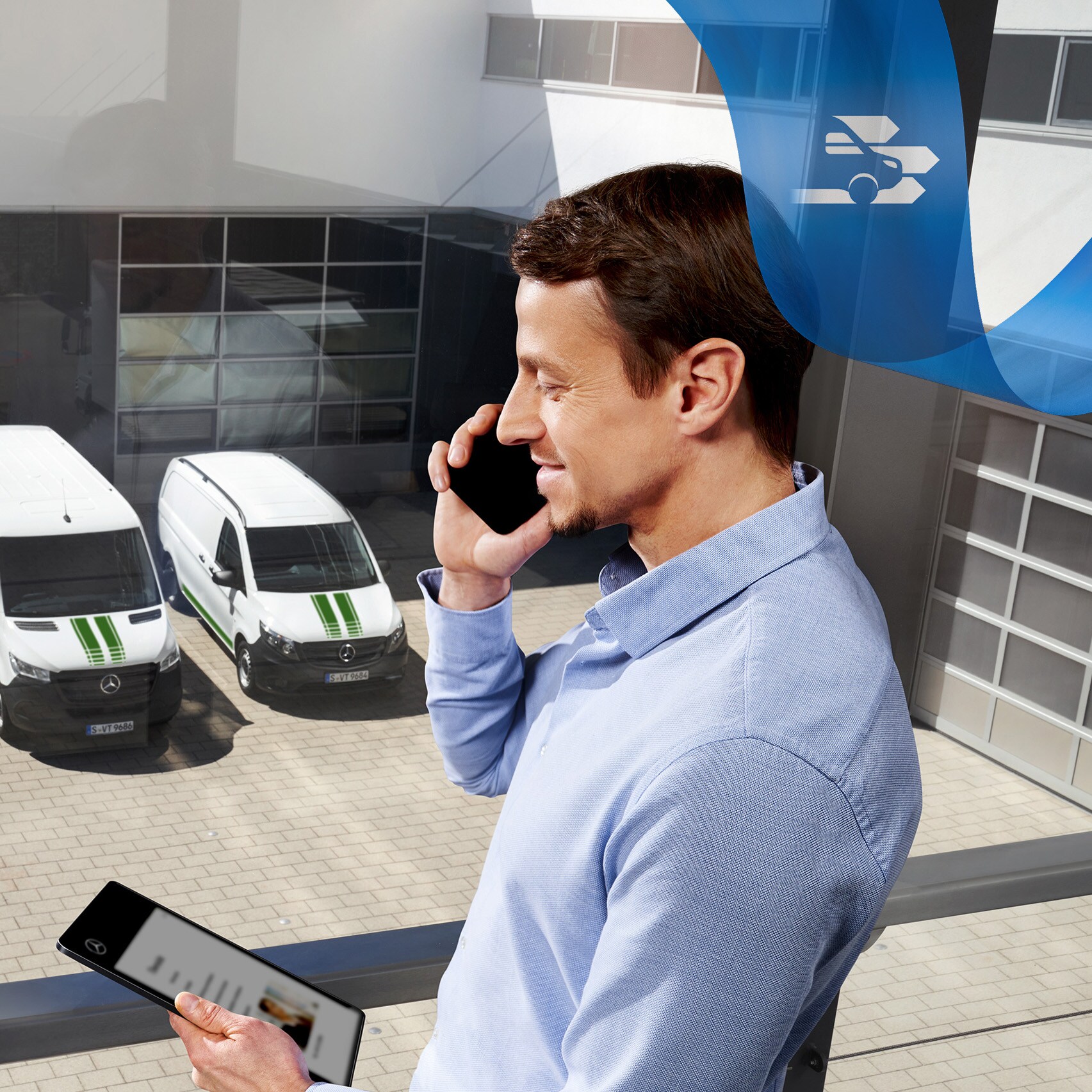 Muž telefonuje, v pozadí je vidět řada dodávkových vozidel Mercedes-Benz