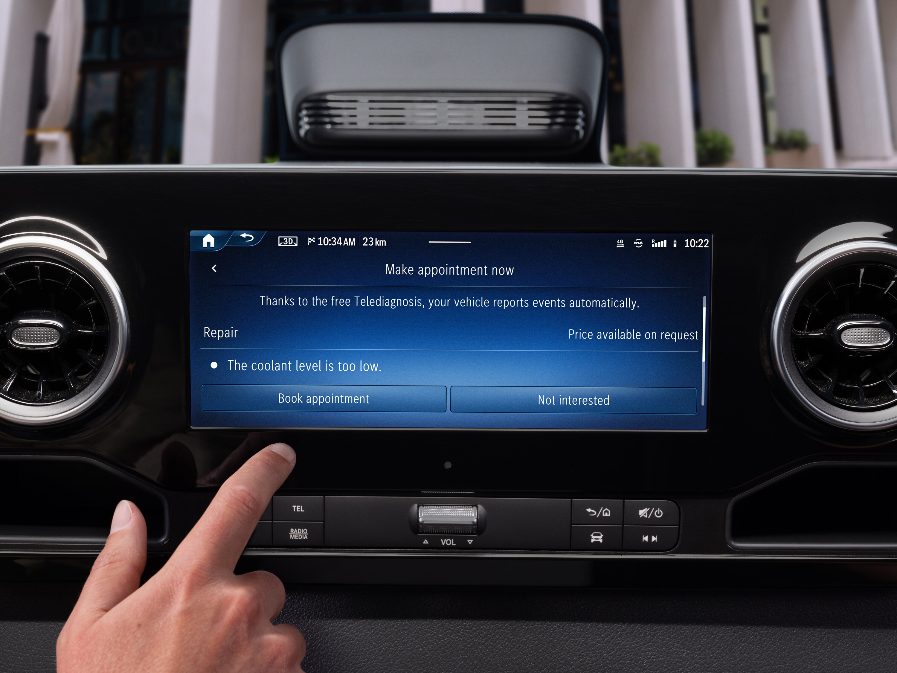Prst klepe na displej ve vozidle pro rezervaci termínu prostřednictvím aplikace Mercedes-Benz Service.