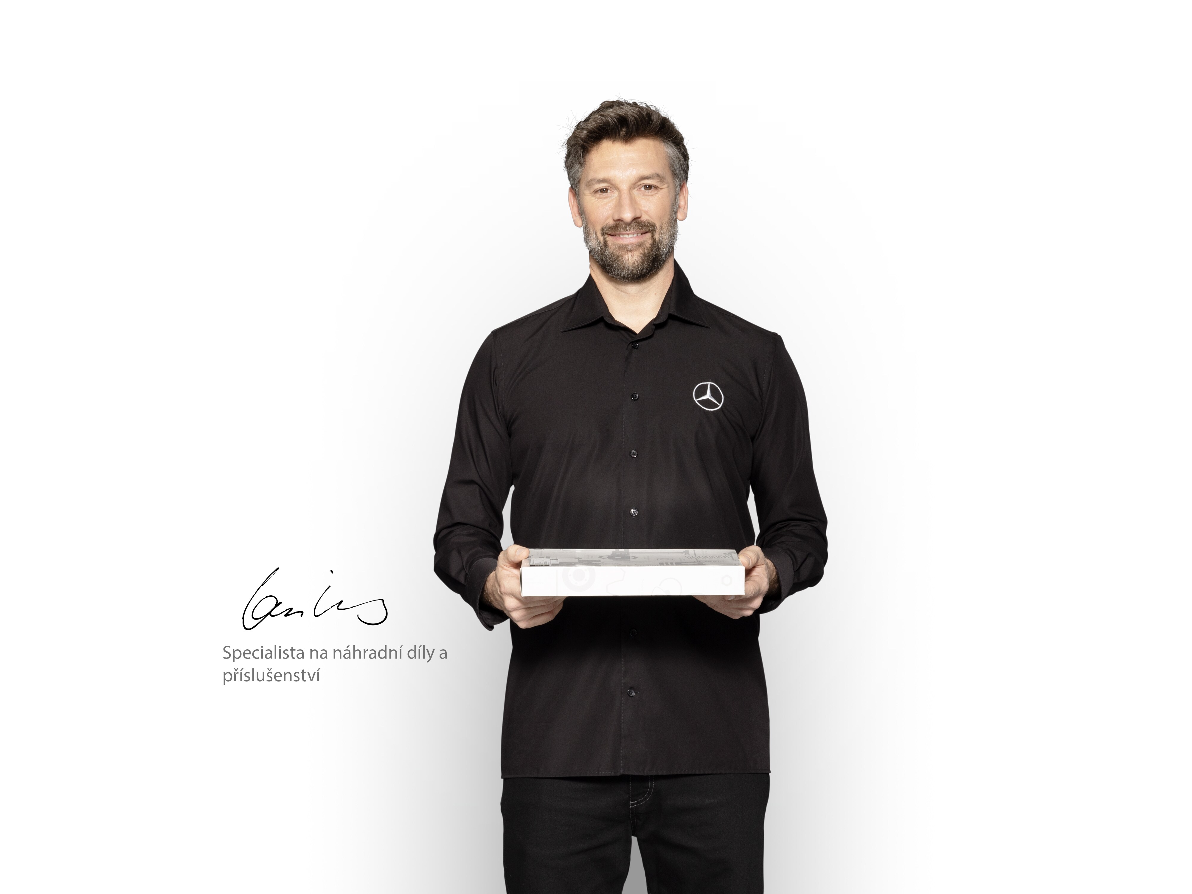 Interní technik Mercedes-Benz s&nbsp;krabicí v&nbsp;rukou, aby ukázal originální díly Mercedes-Benz.